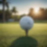 A close-up of a golf ball on a tee with a blurred background of a golf course.